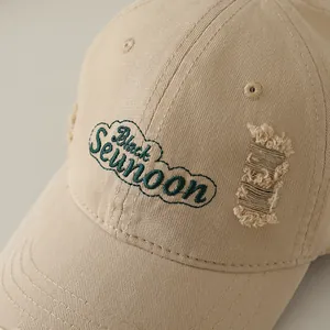 Gros plan détaillé d'une casquette de baseball beige avec broderie verte et effet usé