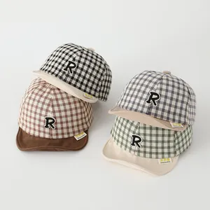 Detail of four colorful infant checkered baseball hats with R patches and soft cotton texture