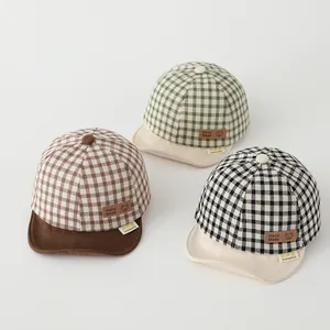 Detail of plaid cotton baby baseball caps featuring bear leather patches and soft brims