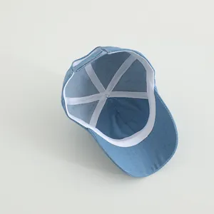 Detail view of denim baseball cap interior with white stitching and adjustable strap