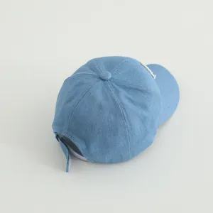 Detail of light blue denim baby baseball cap showing the adjustable back strap and texture