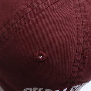 Detailed macro view of the wine red baseball cap fabric with embroidery and stitching
