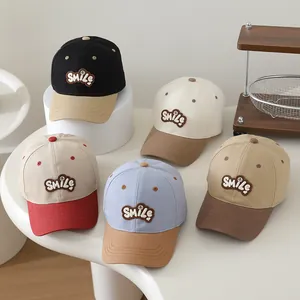 Close-up of kids color-block baseball caps with embroidered Smile patch in five colors