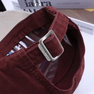 Detailed macro view of the vintage metal buckle and premium twill fabric on a red cap