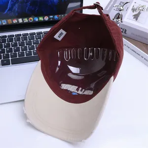 Macro view of distressed brim details and interior embroidery on two-tone baseball cap