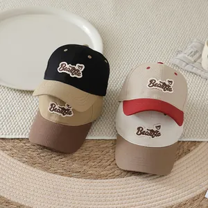 Detail of multi-color kids' baseball caps with Beatfle bear embroidery and contrast brims
