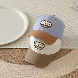Detailed close-up of kids baseball caps featuring letter patches on textured woven mat