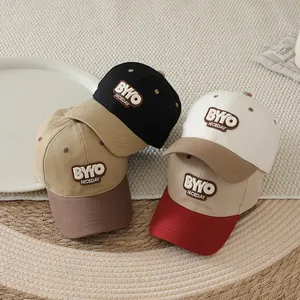 Detail of four colorful kids baseball caps with 3D embroidery on a textured fabric