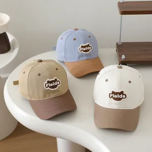 Close-up of kids' baseball caps showing three colorways and bear embroidery details