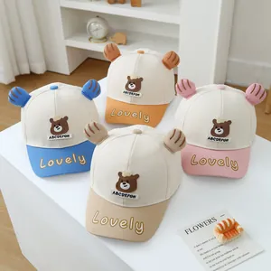 Detailansicht der süßen Bärenstickerei und 3D-Ohren auf bunten Baby-Baseballkappen