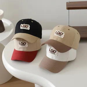 Detail of kids baseball caps featuring LDO SURPRISE patches in various color combinations