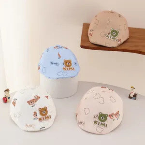 Detail of baby beret hats featuring cute bear patches and KIMI letter embroidery