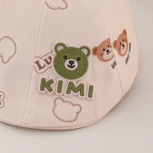 Kids beige cotton sun hat with cute bear patterns and 3D silicone KIMI badge logo