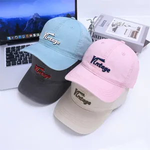Detailed view of four cotton baseball caps with vintage 3D embroidery on a white desk