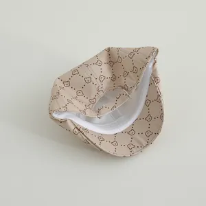 Vista detallada del interior de una gorra beige para bebé con dibujos de ositos y forro