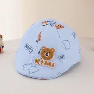 Close-up of baby flat cap with light blue 3D bear applique and KIMI lettering detail