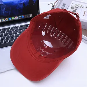 Detail of red cotton kids baseball cap featuring inner lining and metal buckle closure
