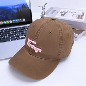 Close-up of pink Vintage embroidery on a brown cotton baseball cap for kids
