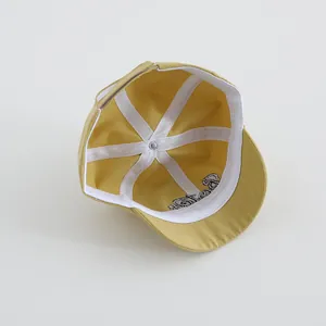 Detalle de la estructura interna y el bordado Boston en una gorra de algodón amarillo