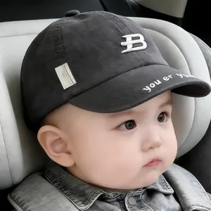 Close-up of baby baseball cap with white embroidered B logo and lettered brim detail
