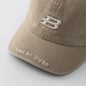 Close-up of khaki cotton baseball cap with white 3D letter B and brim embroidery
