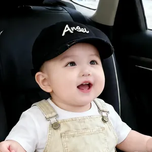 Infant wearing black Boston baseball cap with Angel detail in car seat setting