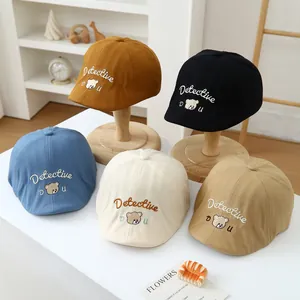 Detail of five colors toddler detective bear beret hats with embroidery on display