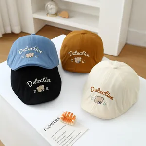 Close-up of four colored baby hats featuring bear embroidery and Detective text