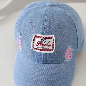 Distressed light blue denim baseball cap for kids with bow patch and vintage torn details