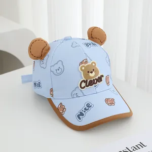 Detail of baby bear baseball cap showing 3D ears and cartoon bear patch on light blue fabric