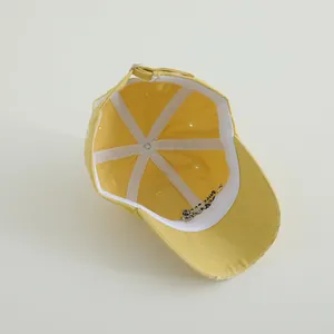 Detail view of the inner structure and embroidery on a vintage yellow cotton baseball cap
