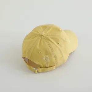 Detail of adjustable metal buckle and vintage distressed texture on kids baseball cap