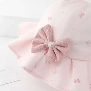 Pink girl's sun hat with butterfly print and large mesh bow on a clean white surface