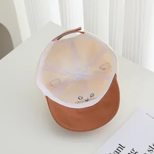 Detail of baby baseball cap interior showing soft lining and bear face embroidery