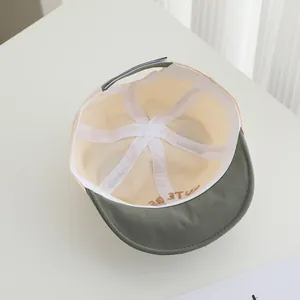 Detailed interior of infant baseball cap showing white reinforcing tape and adjustable strap