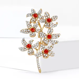 Sparkling crystal flower branch brooch with six red gemstone centers on golden alloy base