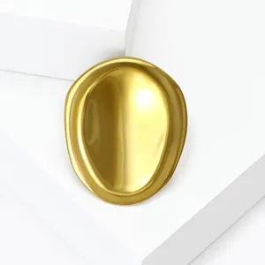 Minimalist golden oval concave brooch pin with elegant matte metal finish on white stand
