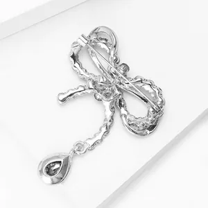 Silver bow brooch with teardrop crystal pendant showing back view with pin fastener