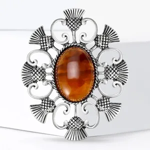 Broche chardon vintage en argent avec pierre ambre ovale et cadre ajouré celtique