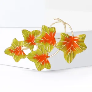 Élégante broche feuille d'érable avec émail dégradé vert et orange sur monture dorée