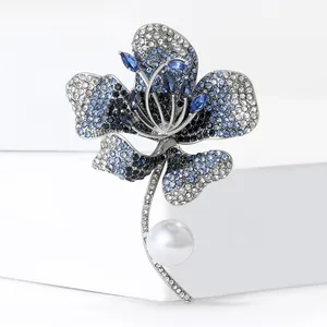 Elegant hibiscus flower pearl brooch with blue and white crystals on white stand