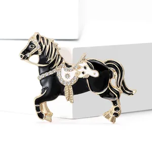 Elegant horse brooch in gold alloy with black and white enamel and sparkling rhinestones