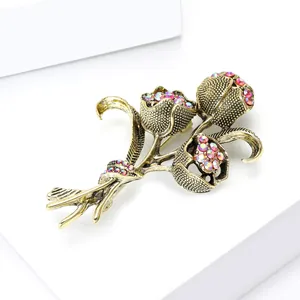 Dettaglio ravvicinato della spilla tulipano dorata vintage con strass rosa lucidi