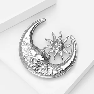 Detail of vintage silver moon and sun brooch with polished metallic liquid texture
