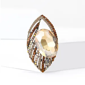 Elegant gold-tone eye-shaped brooch with champagne crystal and sparkling rhinestones
