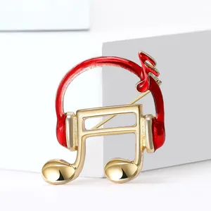 Broche élégante en alliage doré avec casque, note de musique et détails en émail rouge