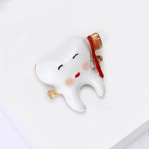 Detail of creative cartoon tooth brooch with enamel brush design and glossy white finish