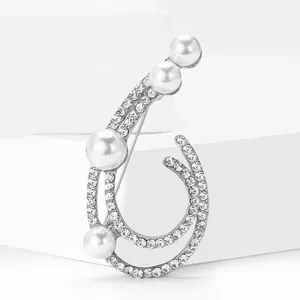 Elegant silver-tone spiral brooch with faux pearls and micro-paved rhinestones on white base