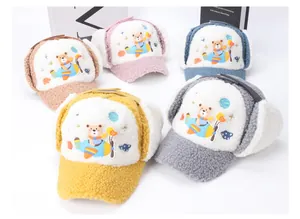 Detail view of colorful children's winter aviator hats with plush ear flaps and bear embroidery