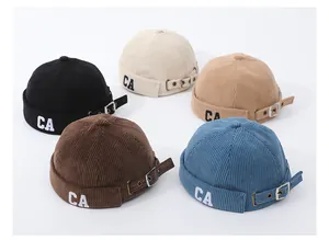 Dettaglio di cappelli docker in velluto a coste con ricamo CA in vari colori e fibbie